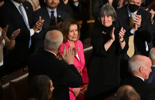 Members of Congress applaud outgoing House Speaker Nancy Pelosi.