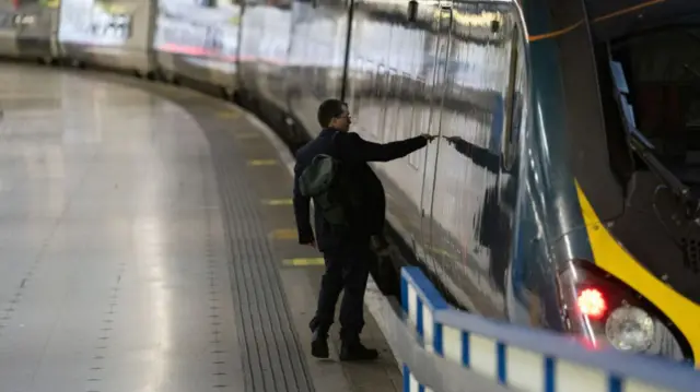 A man boards a train at London Euston