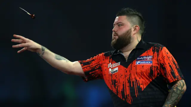 Michael Smith throws a dart