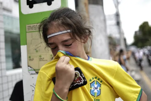 A fan in a Brazil football top crying at Pele's memorial