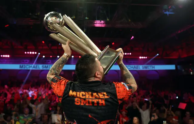 Michael Smith lifts the World Championship trophy