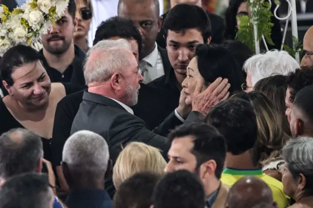 New Brazilian president Lula da Silva embracing Pele's widow at his coffin