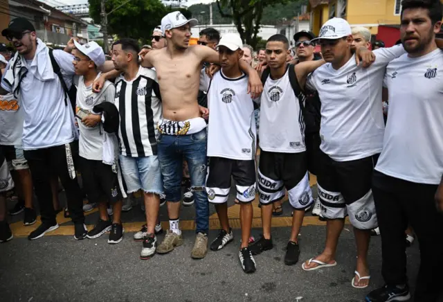 Mourners wearing Santos shirts