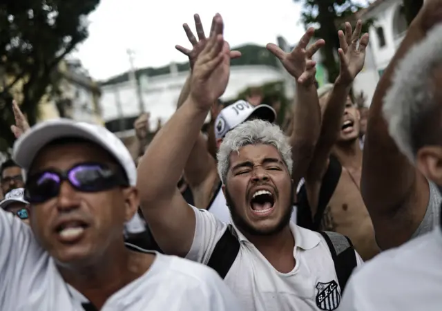 Fans in Santos shirts waiting for Pele's funeral procession