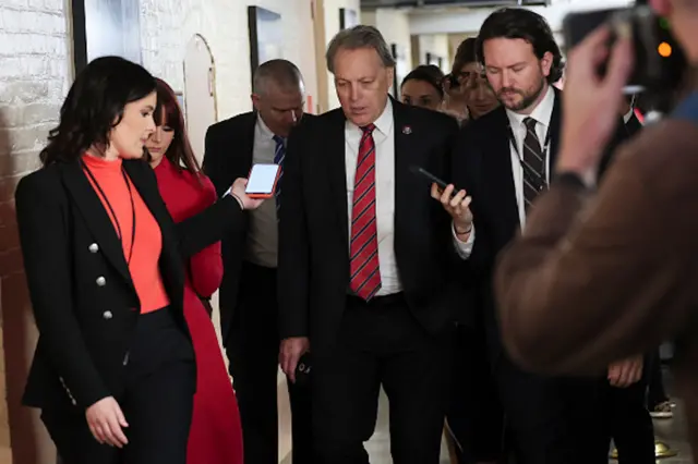 Rep. Andy Biggs walks with reporters while walking to a meeting