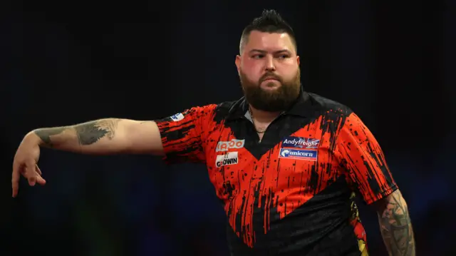 Michael Smith throws a dart