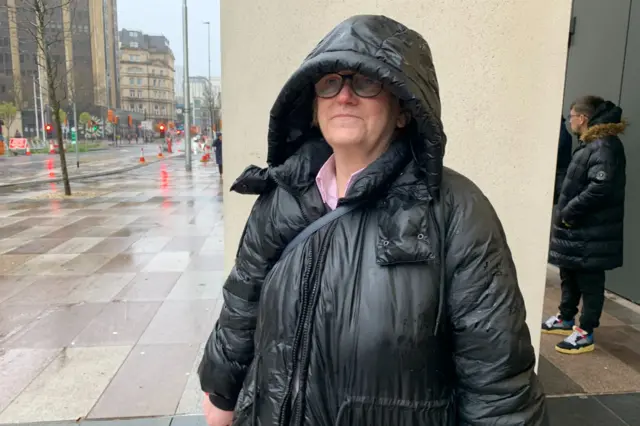 Becky Williams poses for a photo wearing a raincoat