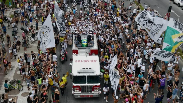 Fans in Santos watch Pele's coffin being carried through the city on a fire truck