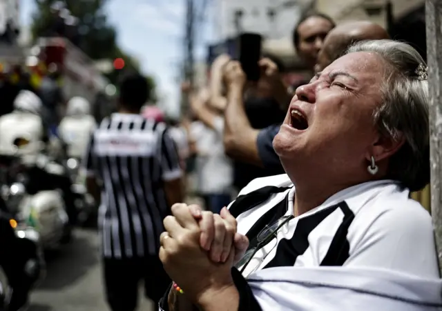 A mourner in tears as Pele's coffin passes by