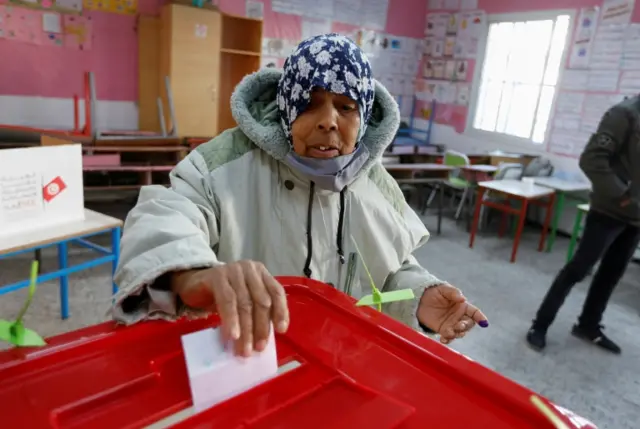 A voter casts her ballot at a polling station during the second round of the parliamentary election in Tunis