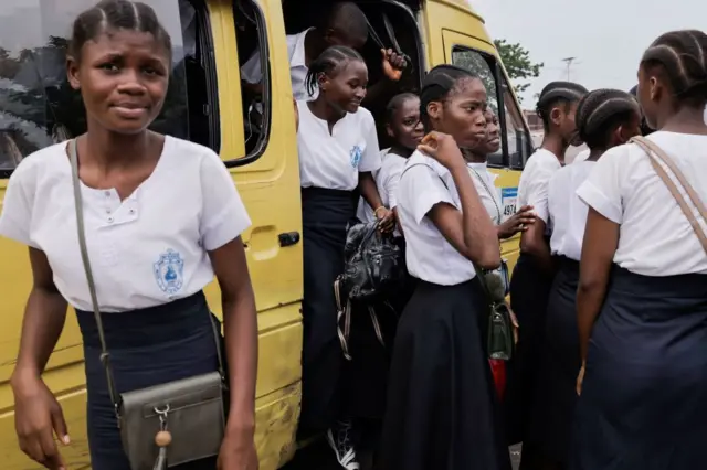 Catholic schoolchildren file off a bus.