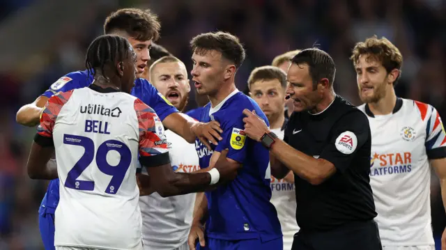 Players clash during Luton's win at Cardiff last August