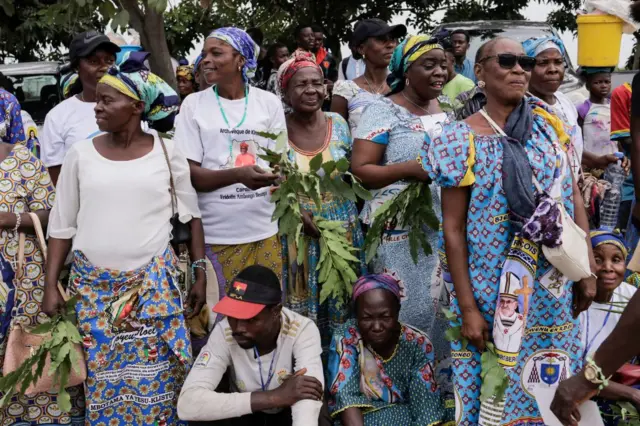 Women wearing special edition cloths await the Pope.