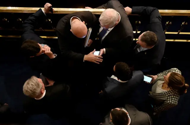 McCarthy consults with his aides as the House goes into recess for three hours