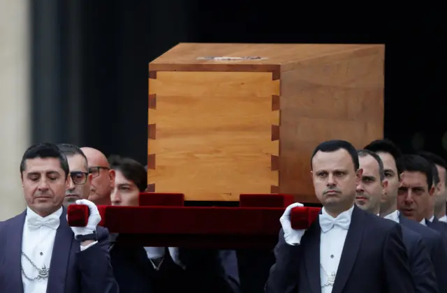 The coffin of former Pope Benedict is carried