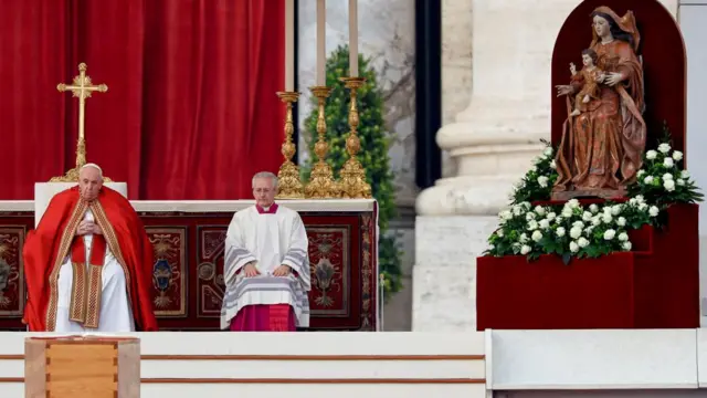 Pope Francis looks on at the coffin of his predecessor Pope Benedict