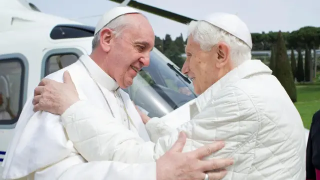 Pope Francis (l) greets his predecessor, Pope Emeritus Benedict XVI