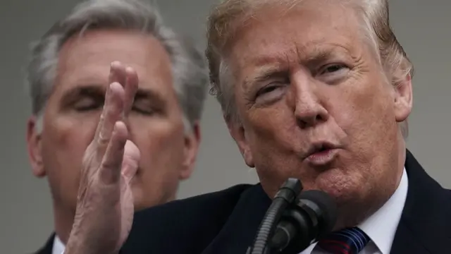 Then-president Donald Trump speaks at the White House, with Republican leader Kevin McCarthy standing behind him, in January 2019.