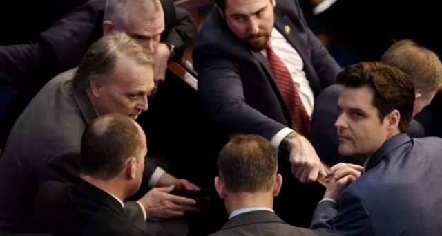 A group of Republicans, including Matt Gaetz (right), huddle in the House chamber