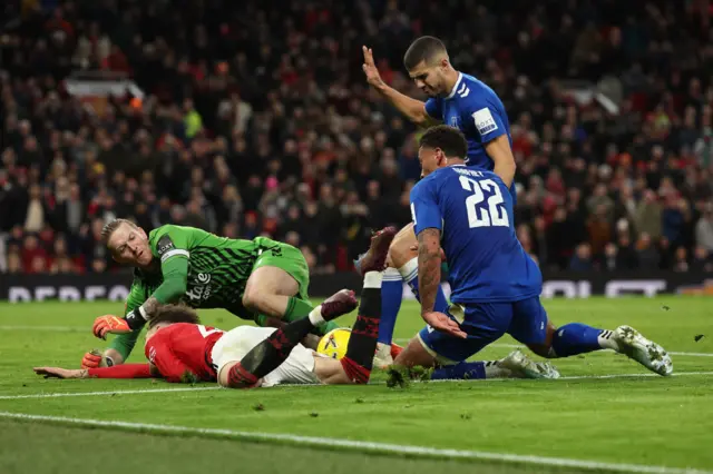 Ben Godfrey bundles over Alejandro Garnacho in the box