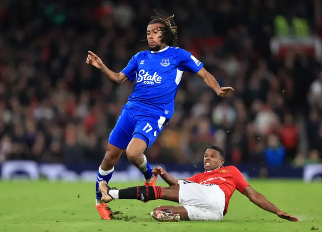 Tyrell Malacia of Manchester United takes out the standing leg of Alex Iwobi of Everton during the Emirates FA Cup Third Round match between Manchester United and Everton at Old Trafford