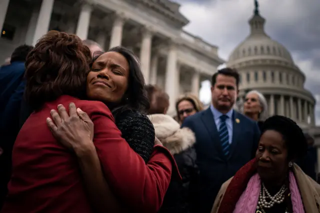 Serena Liebengood, widow of Capitol Police officer Howie Liebengood, hugs Rep. Maxine Waters (D-CA) following a ceremony marking the second anniversary of the January 6 Insurrection on the steps of the House of Representatives at the U.S. Capitol Building