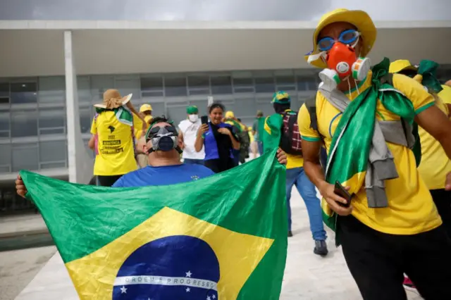 A protester holding a Brazil flag