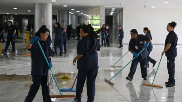 Workers mop the floor during clean up procedures at Planalto Palace in Brasília