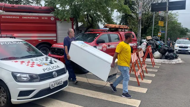 Two men carry a fridge in São Paulo