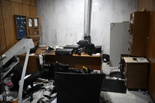 Storage cabinets smashed open with papers on the floor