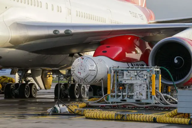 The LauncherOne rocket positioned underneath the wing of Cosmic Girl, the modified Boeing 747.