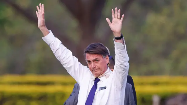 Former Brazil President Jair Bolsonaro with his hands in the air