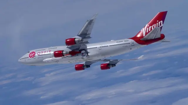 Cosmic Girl, a modified Boeing 747 aircraft, with the LauncherOne rocket attached to it under its left wing