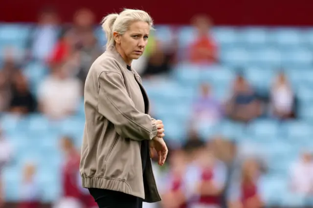 Carla Ward checks her watch on the pitch before kick off.