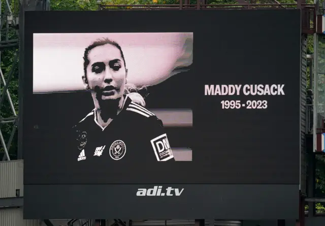 The scoreboard shows an image in memory of Maddy Cusack.