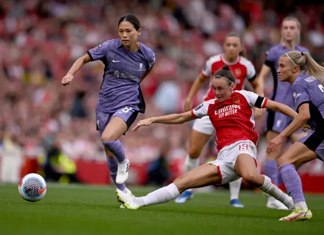 Foord tries to release the ball under heavy pressure from Liverpool players.