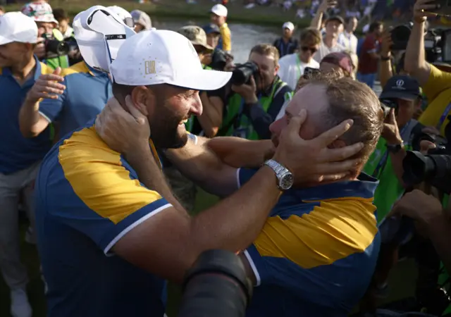 Jon Rahm and Shane Lowry embrace in celebration