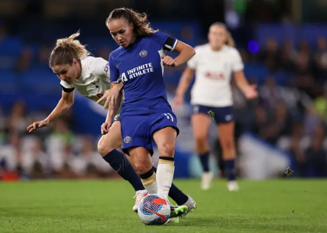 Reiten holds off the challenge of a Spurs defender.