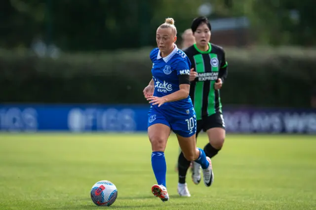 Bennison runs up field with the ball while being chased by a Brighton defender.