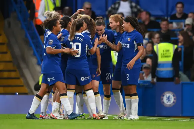 Chelsea players gather together to celebrate the opening goal.