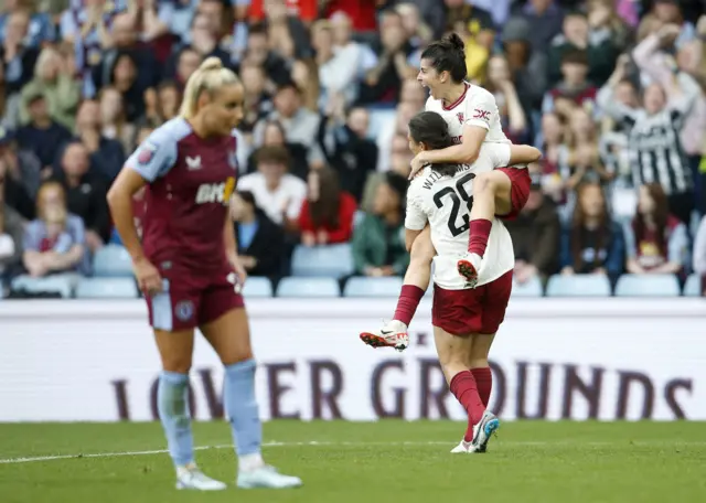 Leon stands desconsolate while United celebrate their winner.