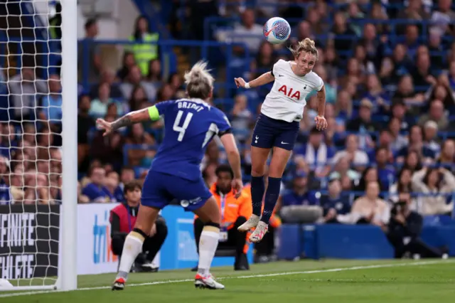 Thomas heads the ball towards goal as Bright gets set to clear danger.