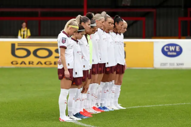 City players bow their heads and stand together for the moment's silence.