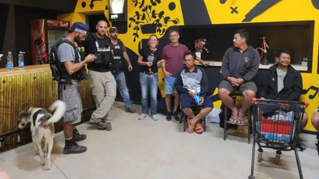 A group who became trapped in a southern Israeli kibbutz smile after being saved by officials