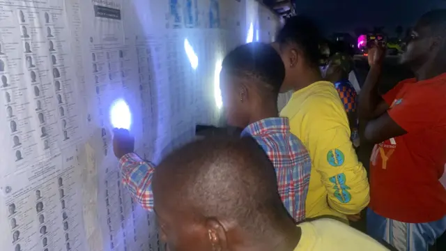Liberians using torches to see the voters' roll