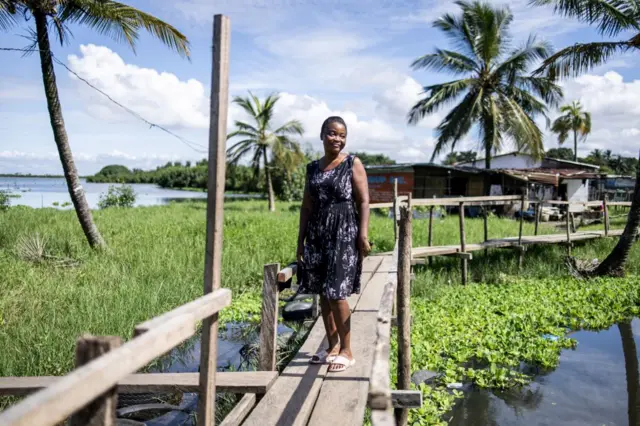 A woman poses for a portrait on her way home after voting in Fredrick's Island in Monrovia on October 10, 2023.