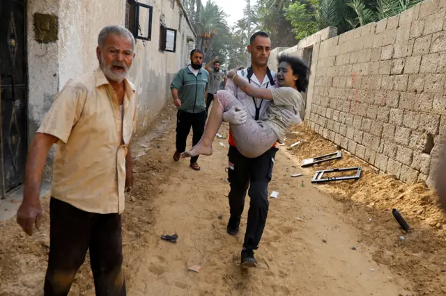 A man carries a wounded Palestinian girl at the site of Israeli strikes on houses, in Khan Younis in the southern Gaza Strip October 11, 2023. REUTERS/Ibraheem Abu Mustafa