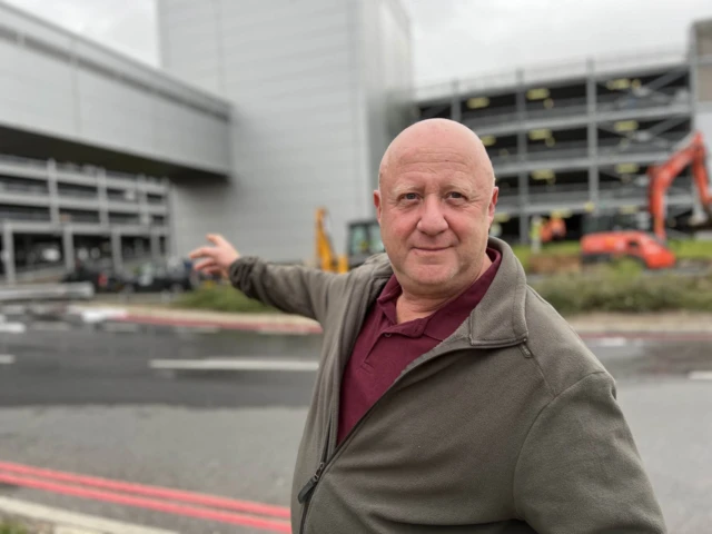 Chris Meacey pointing at the car park where his van is trapped