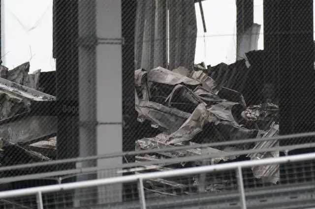 Burnt out shells of cars that are also flattened