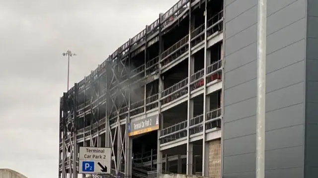 Terminal 2 car park entrance covered in black smoke residue and with some smoke still coming out.